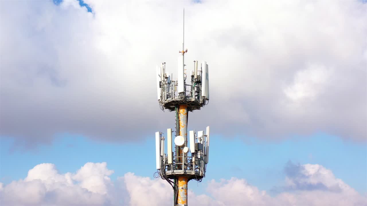 Cell Tower with Antennas Against a Cloudy Sky