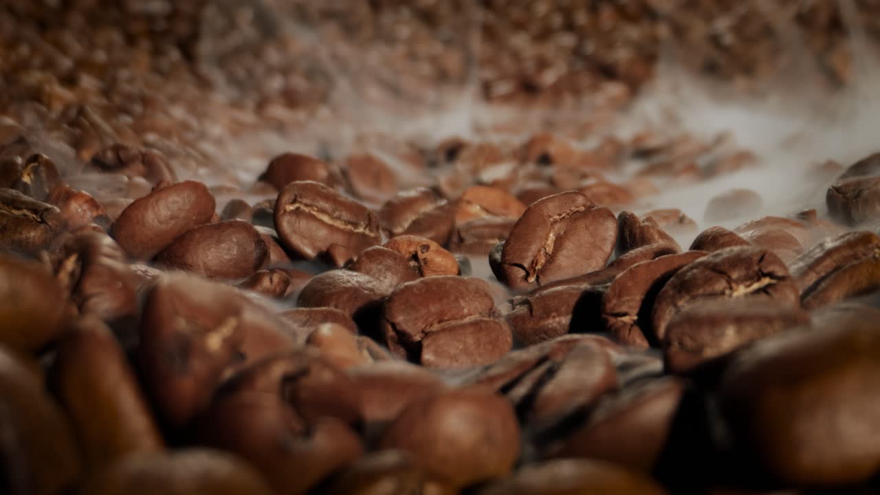 Close up of seeds of coffee. Fragrant coffee beans are roasted smoke comes from coffee beans.