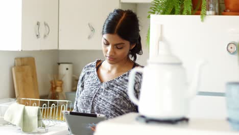 mujer usando una tableta digital en la cocina
