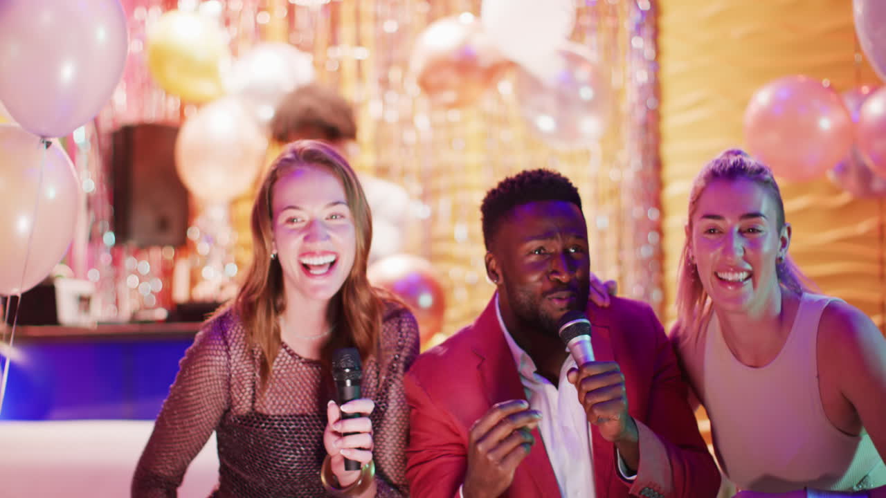 Video of diverse happy group of friends signing karaoke at a nightclub bar