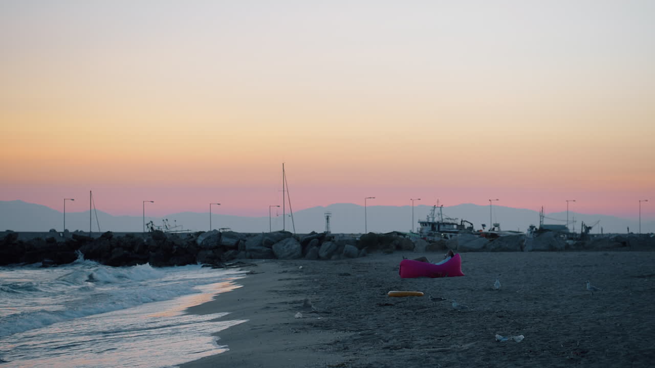 Man relaxing at the beach and evening scene of sea with gulls