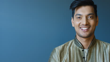 Close-up-view-of-indian-young-man-in-traditional-clothes-turning-his-face-and-smiling-at-camera