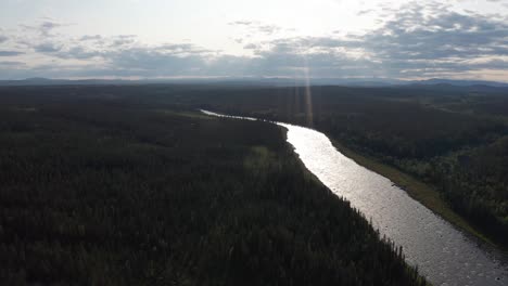 drone shot of wild river in northern sweden surrounded by deep forest