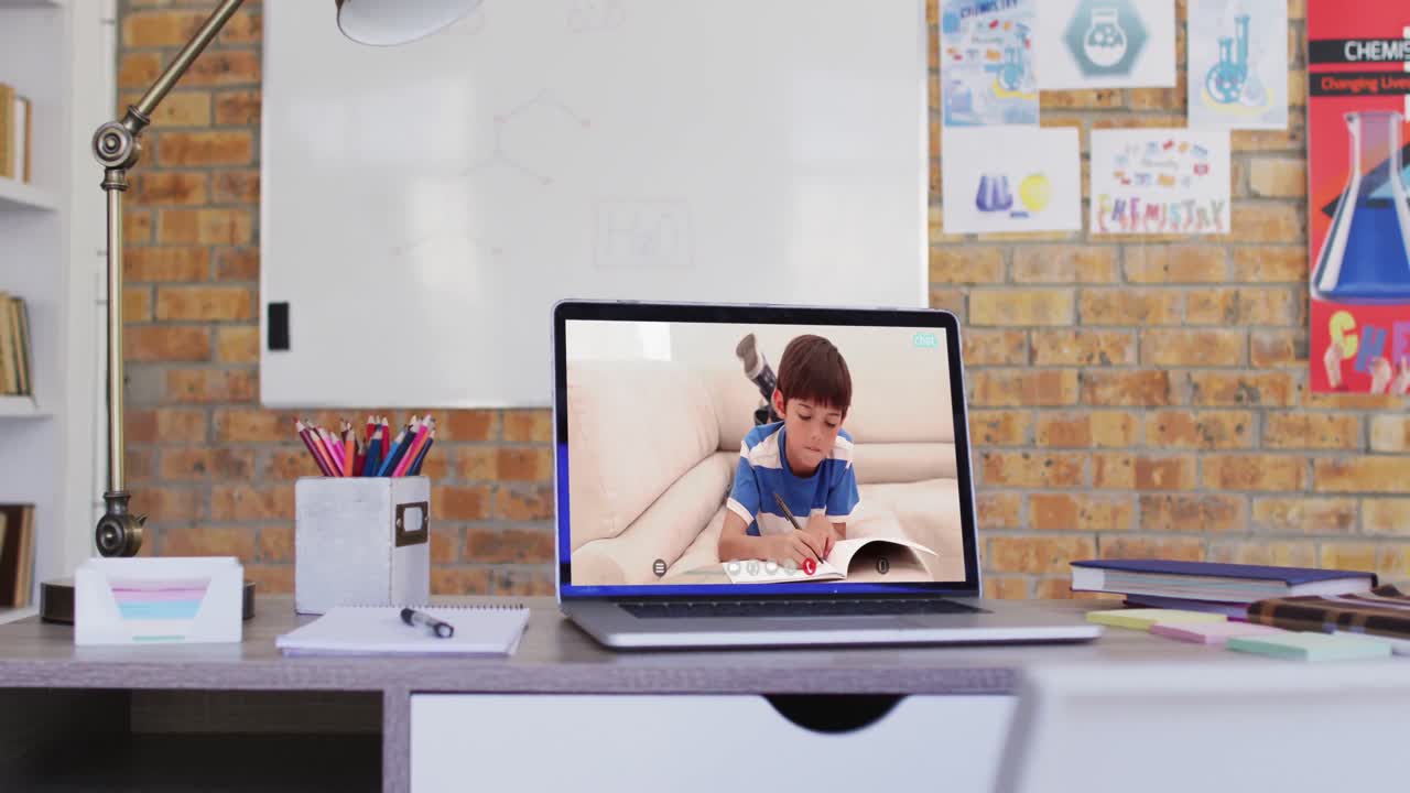 niño de escuela caucásico aprendiendo mostrado en la pantalla del portátil durante una videollamada