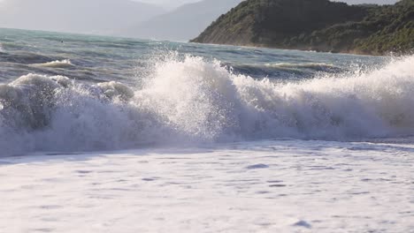 disparo en cámara lenta de olas espumosas aplastando en la playa en un día de verano