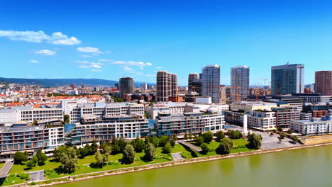 view on the buildings at the waterfront of the danube river. cityscape of bratislava, slovakia at the backdrop of blue sky. aerial perspective.