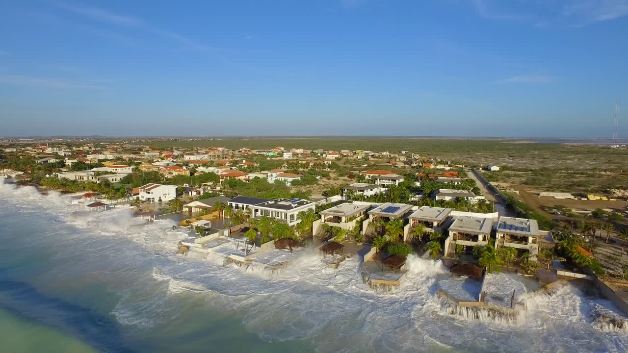 grandes olas dañando casas después de que un huracán pasara por la costa de bonaire