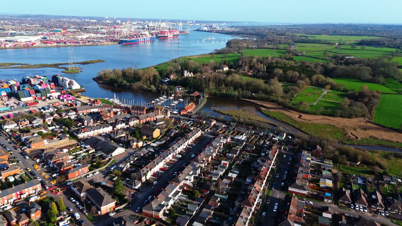 Flugschwenk über den Vorort Totton westlich des Flusses in Southampton, England, mit Autos auf den belebten Straßen und Sonnenlicht, das sich im Winter auf dem blauen Flusswasser mit Booten darauf spiegelt
