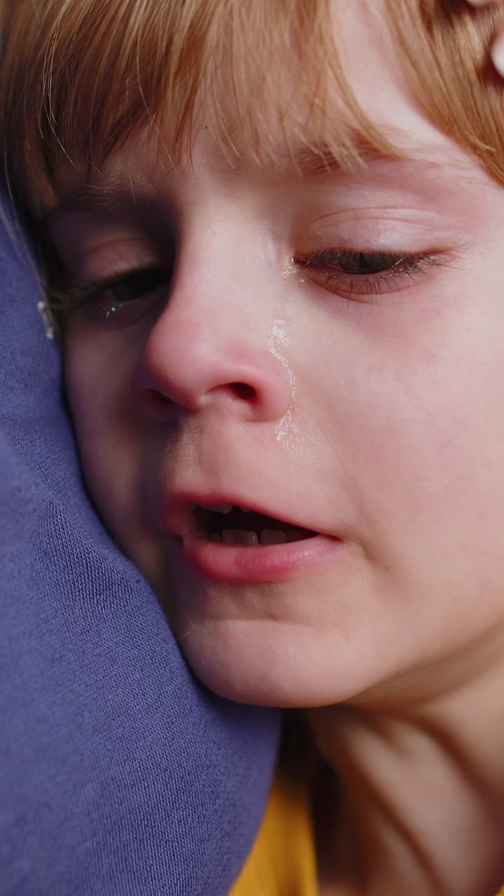 Upset child little girl kid crying with tears flowing down on cheek toddler lies on mother at home