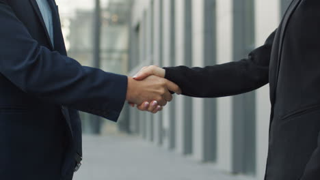 vista de cerca del hombre de negocios y la mujer de negocios dándose la mano en la calle