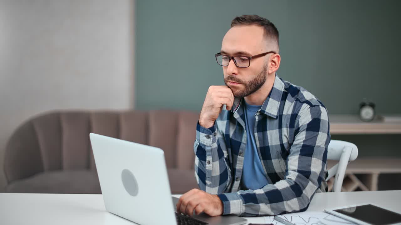 pensativo hombre independiente pensando mirando portátil sentado en el escritorio. disparado en red raven cámara de cine 4k