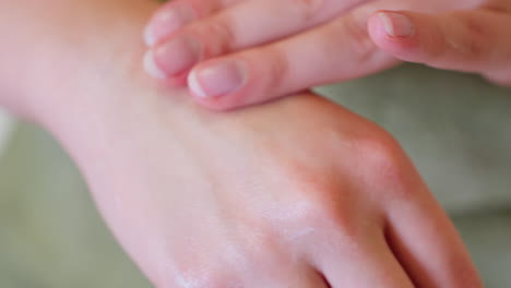 close-up view of woman rubbing cream between hands, focusing on skin moisturizing, the image captures the soft and smooth application of cream, highlighting gentle self-care