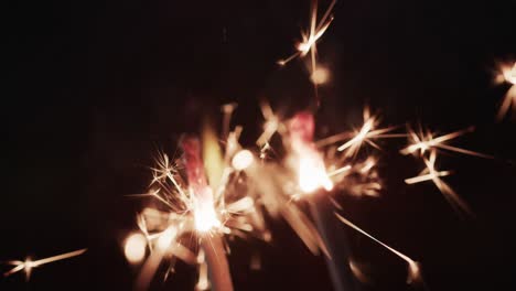 Video-of-close-up-of-sparklers-and-copy-space-on-black-background