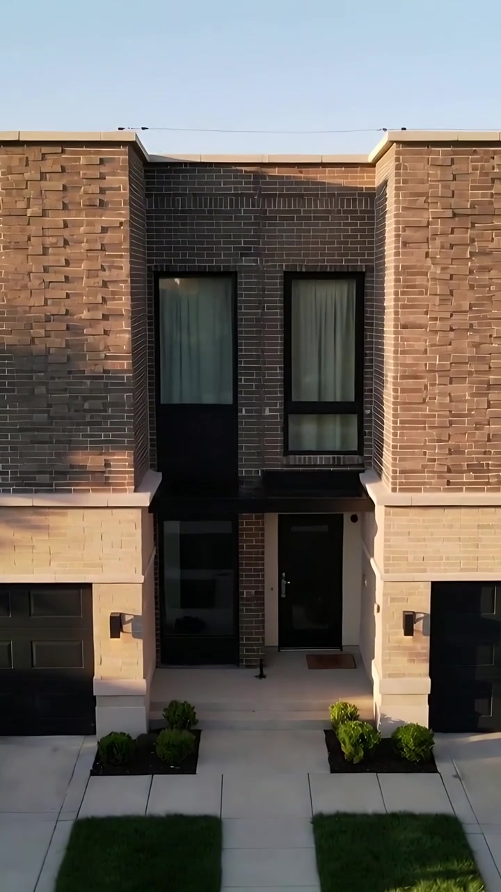 Video vertical: Dron descendiendo, centrando una vivienda de dos plantas en un suburbio, mostrando la ventilación del tejado y la puerta.