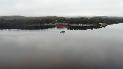 Antena:-Drone-Volando-Alrededor-De-Un-Barco-De-Pesca-En-Un-Gran-Lago-En-Strahan-Tasmania,-Australia