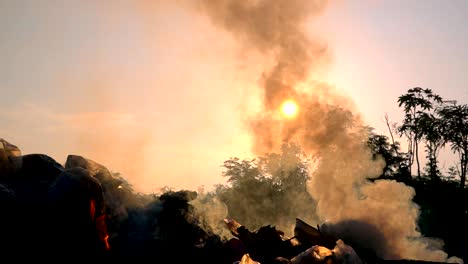 slow motion fire burning garbage bag on sunrise dark backgorund.