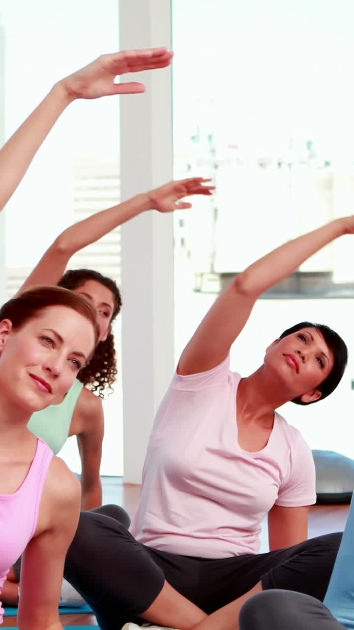 mujeres sonrientes haciendo yoga en el estudio de fitness