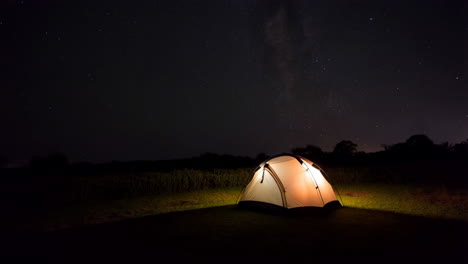 illuminated tent under a starry night sky