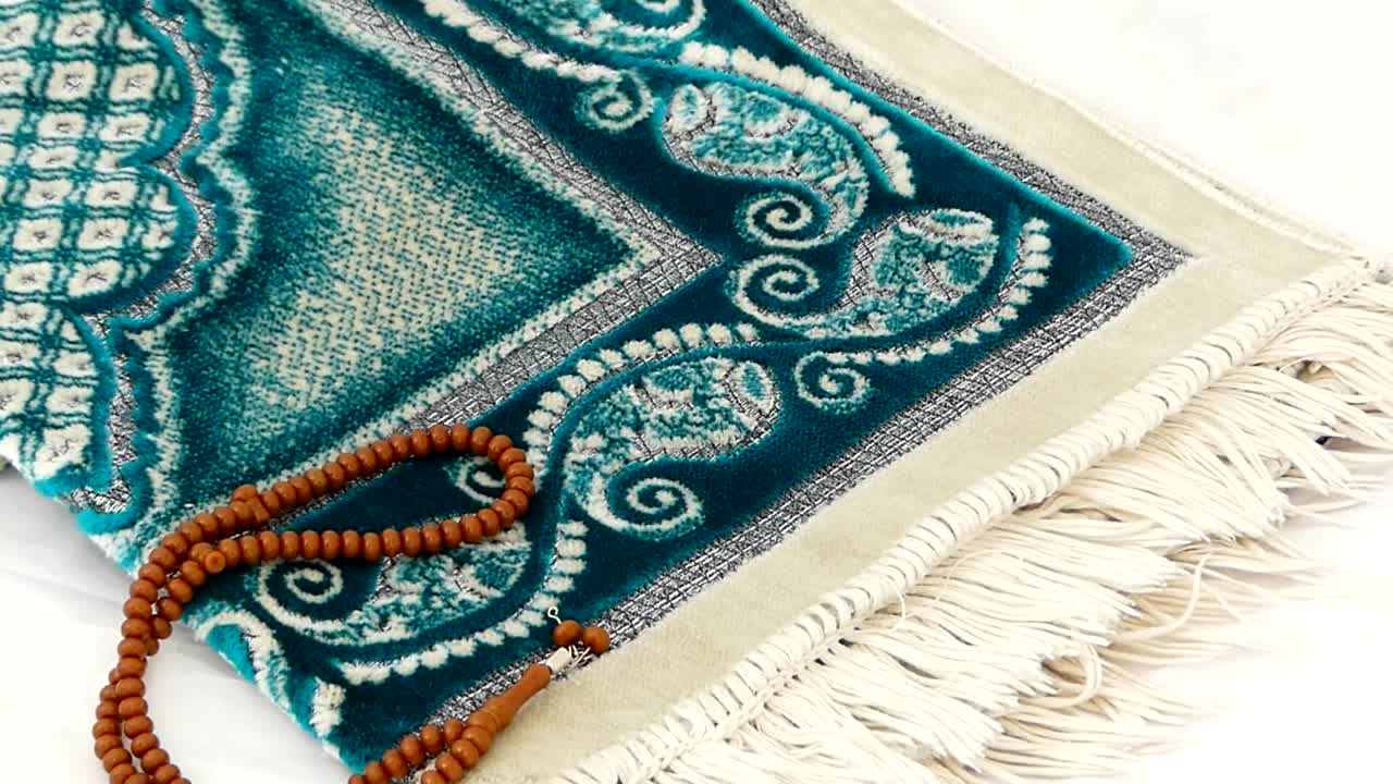 Primo piano di tappeto da preghiera e rosario, Islam e tappeto da preghiera, dove i musulmani pregano in prostrazione.