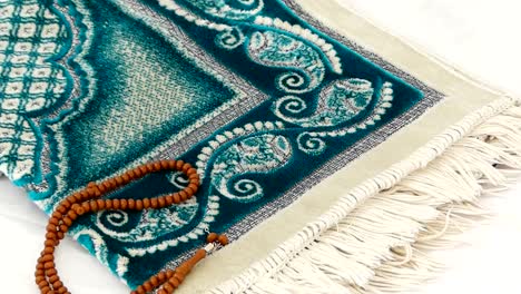 close-up prayer rug and rosary, islam and prayer rug, on the prostration muslims pray on,