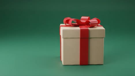 a beautifully wrapped gift box with a red ribbon, perfect for special occasions, holiday celebrations, and surprise parties on a soft green background