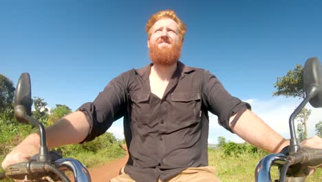 redhead man riding a motorbike on a sunny day