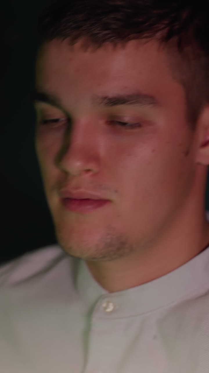 셔츠를 입은 빌리어드 선수는 어두운 배경에서 강렬한 집중과 집중력을 보여줍니다. 눈은 결단력으로 잠겼고,  빌리어트 공을 보면서 큐 스틱을 잡고 있습니다.