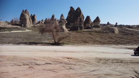 las chimeneas de hadas de capadocia: paseos turísticos en un vehículo de cuatro ruedas más allá de formaciones rocosas geológicas formadas por la erosión