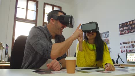 Male-and-female-graphic-designers-using-virtual-reality-headset-at-desk-4k