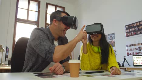diseñadores gráficos masculinos y femeninos usando auriculares de realidad virtual en el escritorio 4k