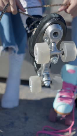 person lacing up roller skates outdoors