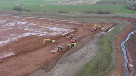 drone footage of a construction side with excavators loading trailers