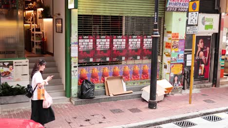 pedestrians pass by a storefront in hong kong