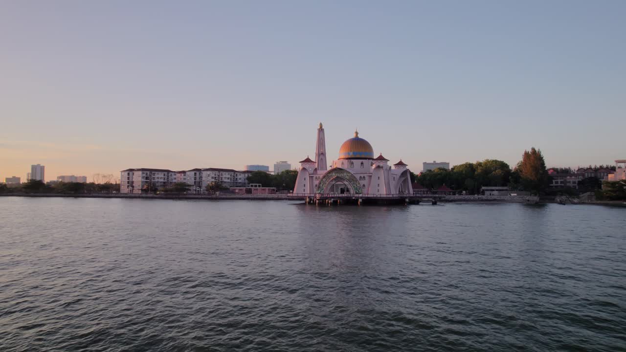Drone footage of Masjid Selat floating mosque at golden hour, highlighting its position above the water in Melaka, Malaysia