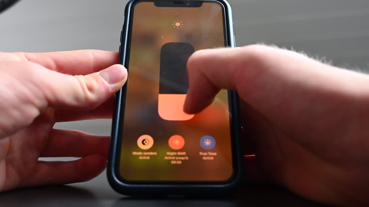 un usuario de teléfono cambia el brillo de su teléfono en la configuración, el uso de su móvil a su propia comodidad