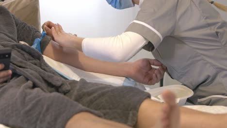 enfermera preparando el brazo del paciente frotando una toallita antiséptica antes de extraer sangre de la vena