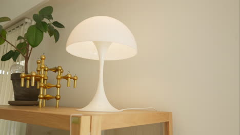 modern desk with a stylish lamp and golden sculpture in a bright room