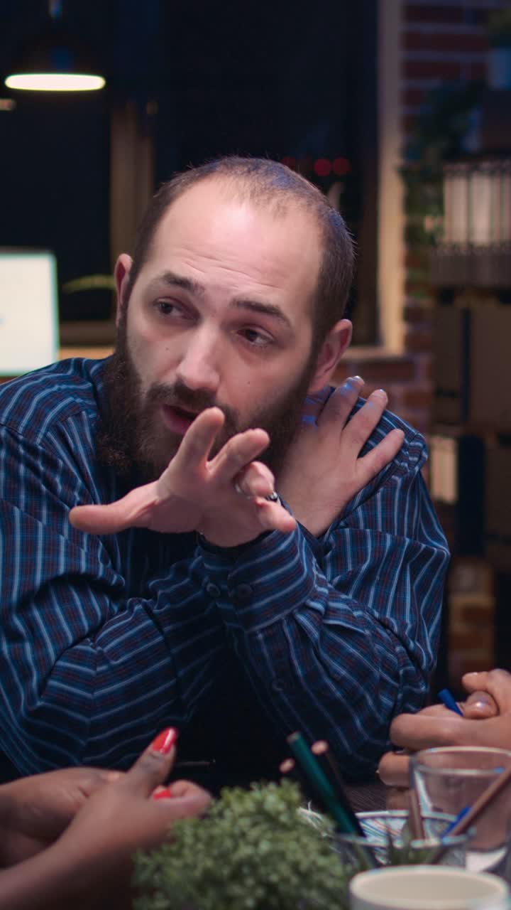 Video verticale: diversi colleghi che fanno brainstorming in una riunione di lavoro, discutendo di una presentazione