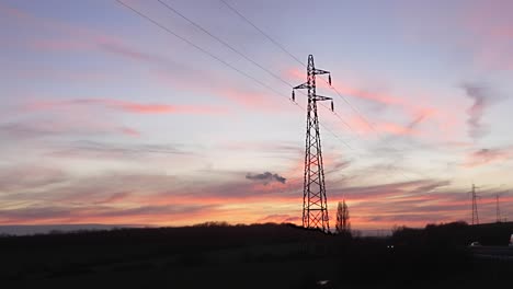 cars zoom drive by on country road at sunset as wispy cloud layers float at golden blue hour dusk