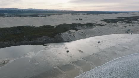 Aerial-Drone-shot-of-Truck-Driving-on-Pismo-Beach-California-Through-Water-at-Sunrise