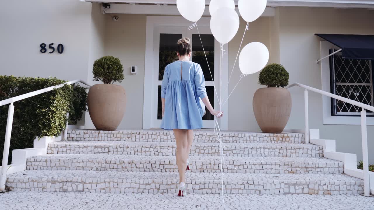 행복한 아름다운 라틴 여성이 도시를 고 있습니다. 젊은 금발 소녀는 느린 동작으로 하루를 즐기고 있습니다. 풍선과 함께 도시에서 습니다.