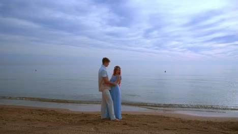 pregnant couple beach. pregnant couple hugging on sea beach. love couple beach