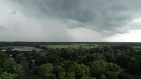 an aerial shot of cloudy sky with rare dark gray clouds with threat of rain over the beautiful meadow