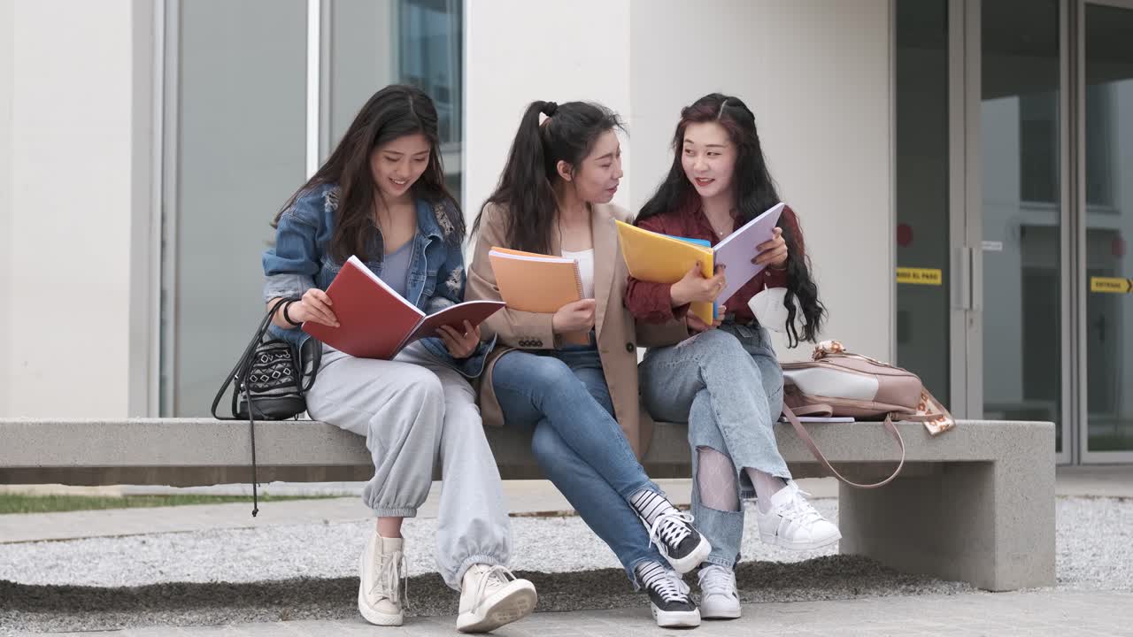 three asian girl students talking at break time sitting on campus