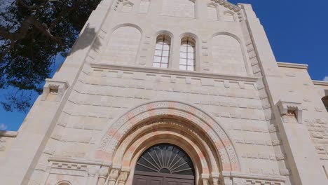 exterior of a stone church with tree