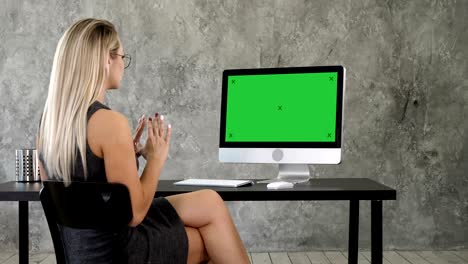 video call conference chatting communication concept. lady in office talking to someone on her computer. green screen mock-up display