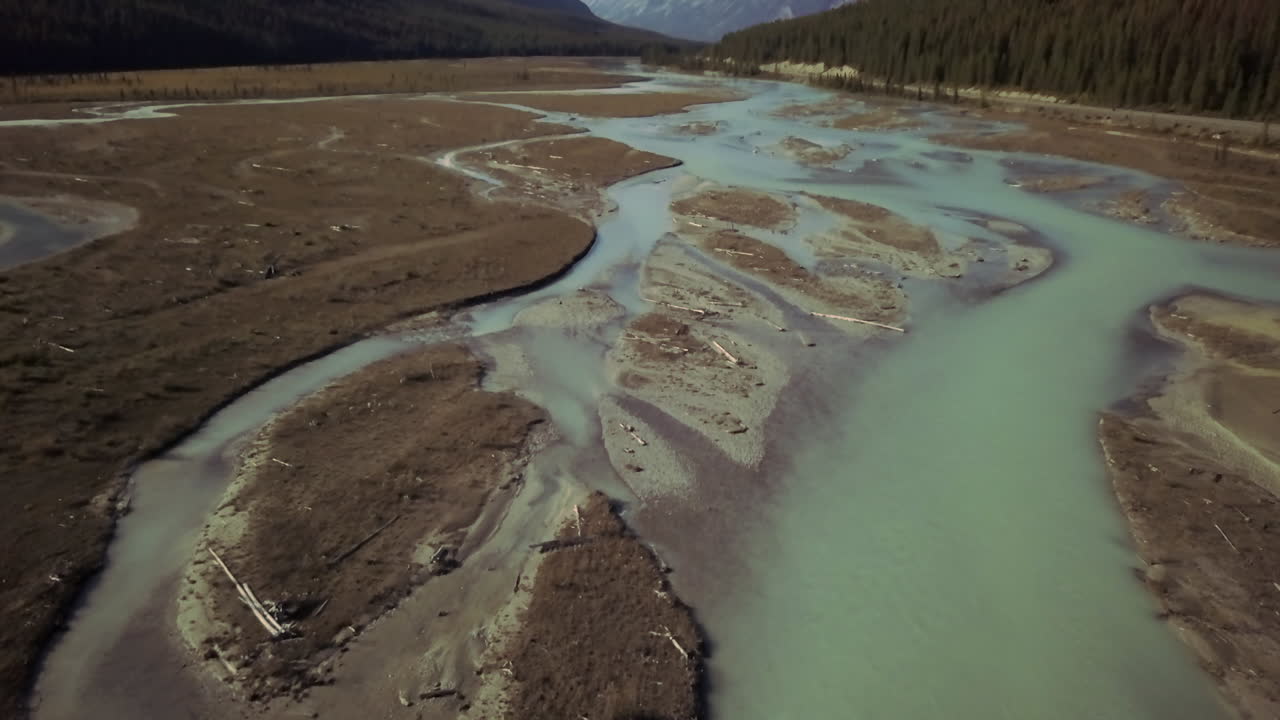 The mineral rich aquamarine waters of the Saskatchewan River, Alberta, Canada, aerial dolly tilt down