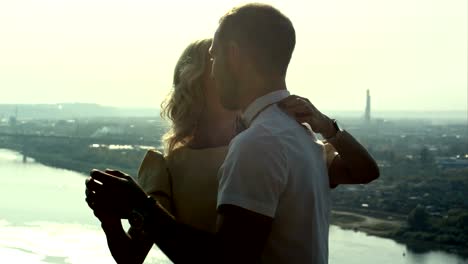 young couple, guy holding woman in arms, looking at each other, dance pose