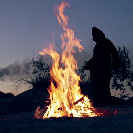 wicked witch holds ritual by the fire. halloween costume.