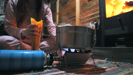 cocinar pasta con una estufa de gas portátil en una cabaña en la naturaleza, al aire libre, acampar